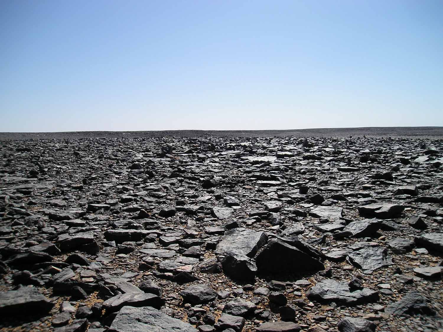 The black desert in the Libyan Sahara - Desert varnish makes the rocks go black - (c) followmefaraway.com